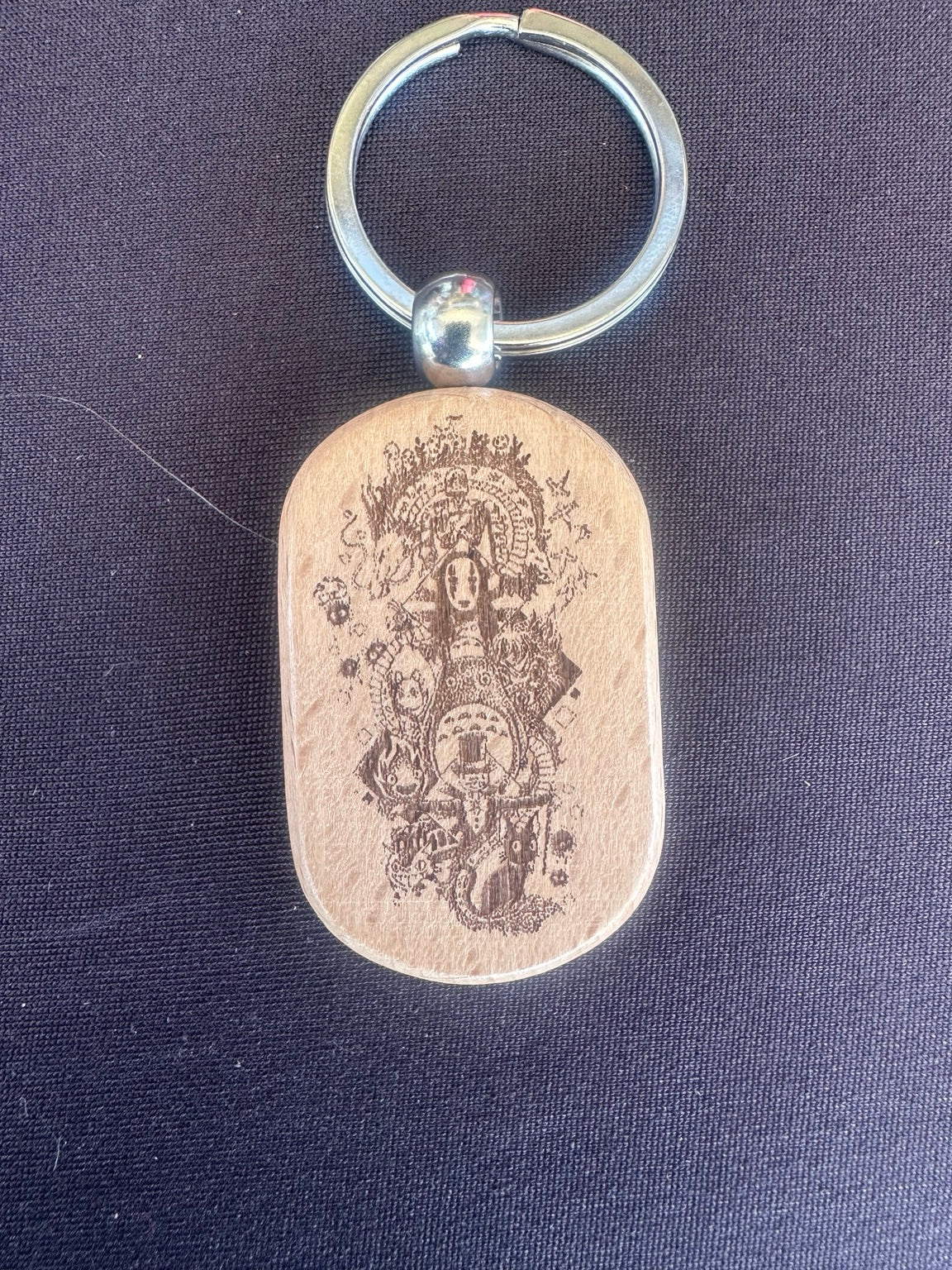 Laser engraved wooden keychain with whimsical Alice in Wonderland inspired design